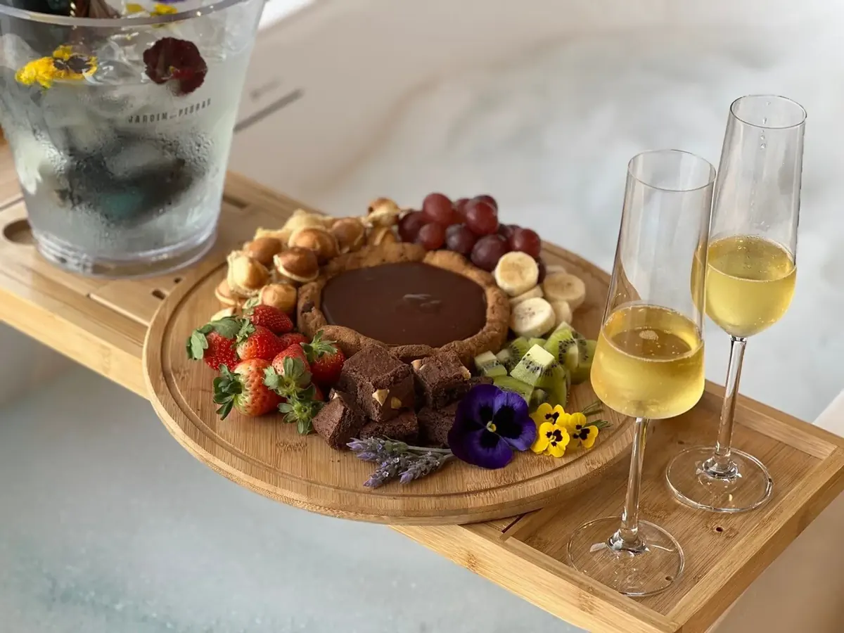 Bandeja com frutas e taças de espumante sobre a banheira de imersão