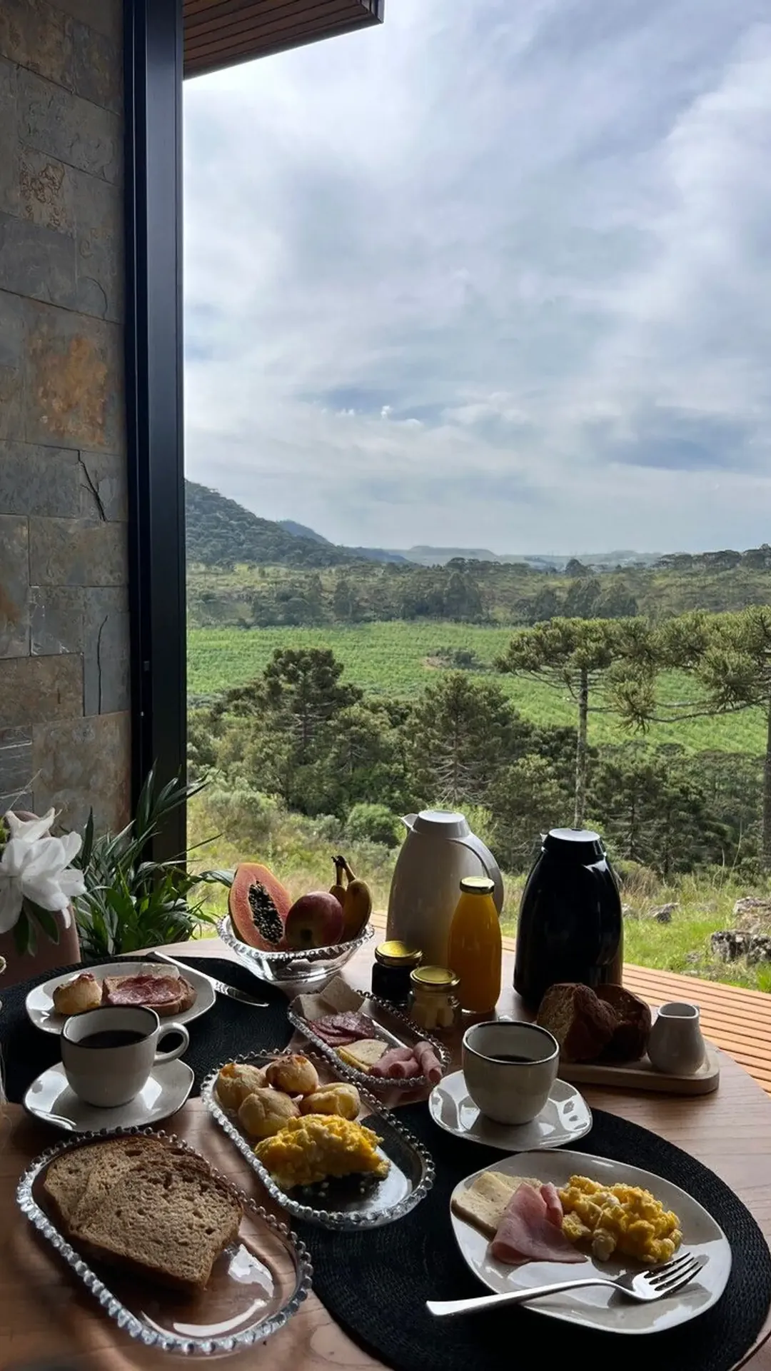 Café da manhã servido na mesa da cabana, diante do campo